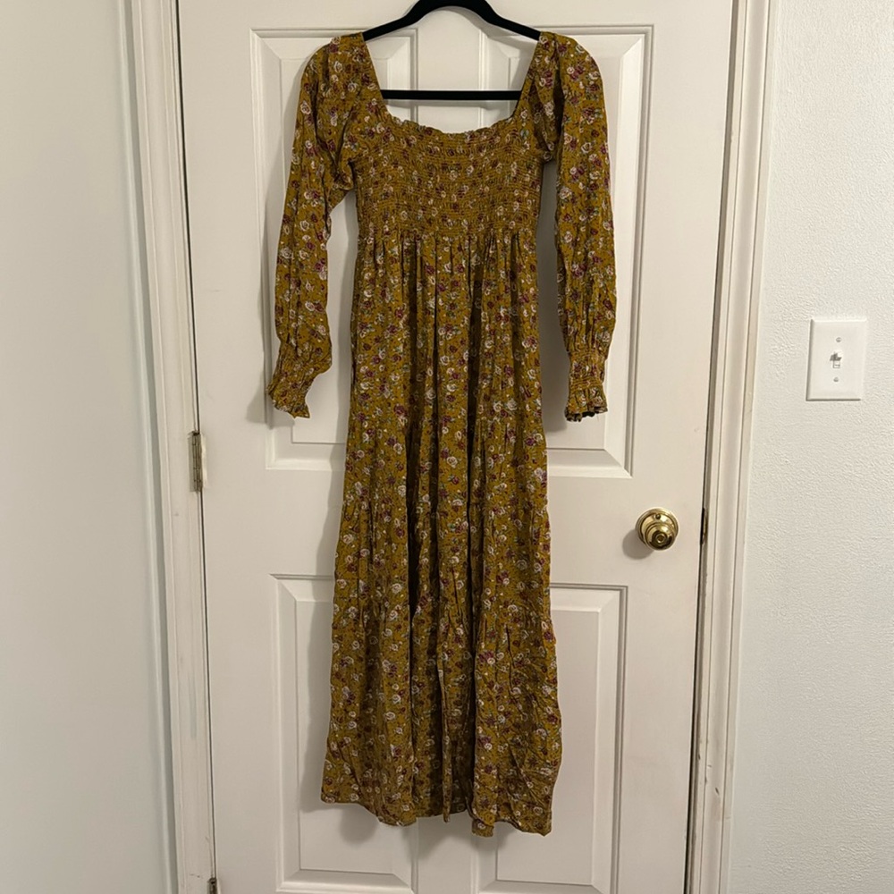 Easel, small, dark mustard colored with pink and mauve roses dress, long sleeves